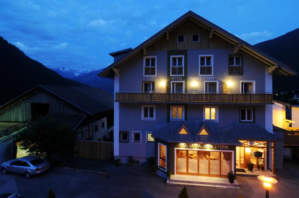 a large house with a car parked in front of it at Hotel Tauernstern in Winklern