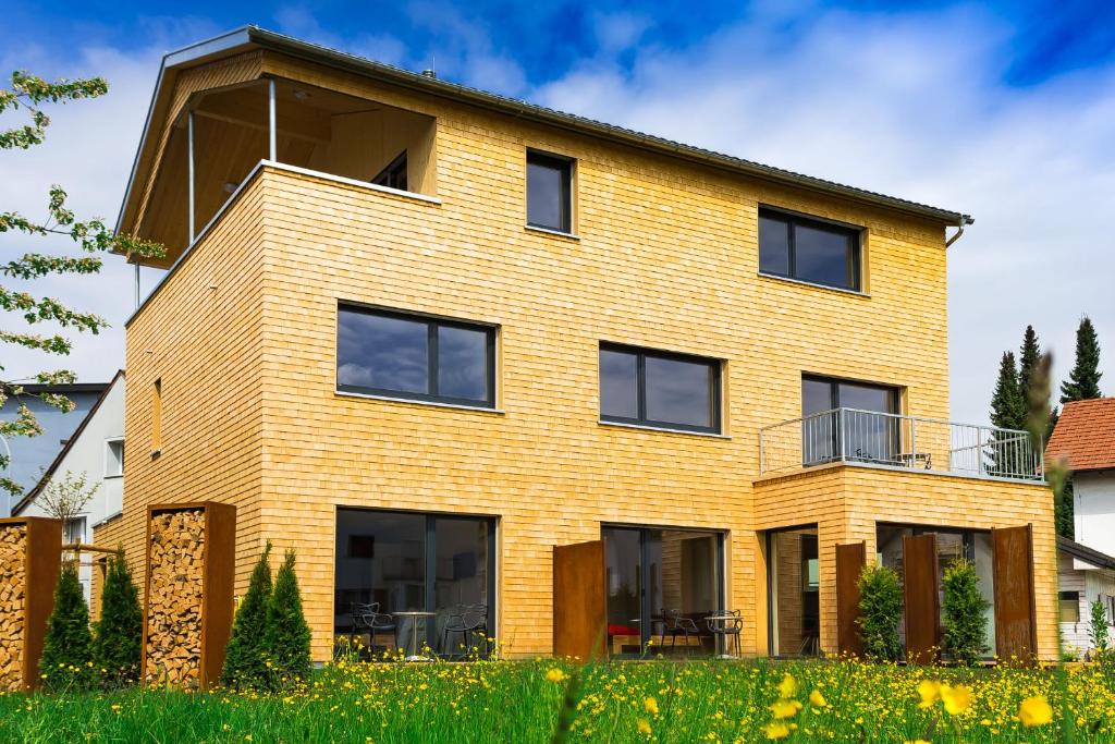 a yellow brick house with black windows at Gästehaus Gritsch in Hard