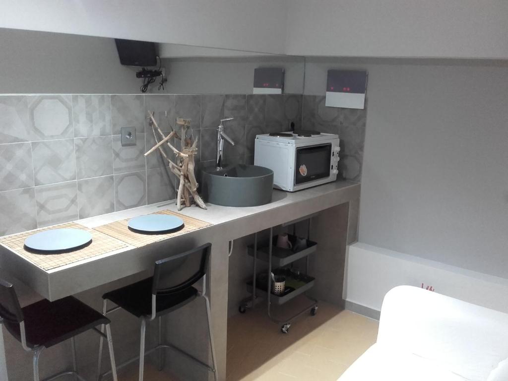 a kitchen with a counter with a microwave and a table at Jennys Apartment in Preveza