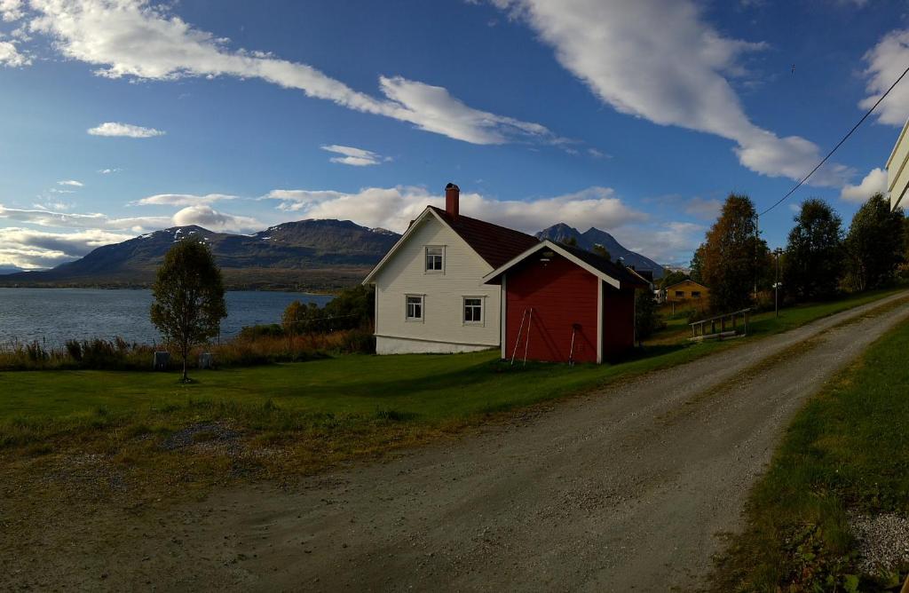 una casa roja y blanca al lado de un camino de tierra en Bustad en Larseng