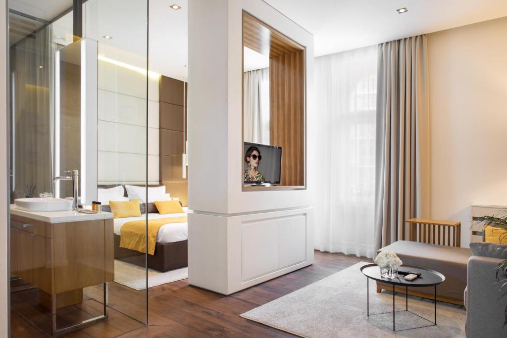 a hotel room with a bed and a television and a bathroom at Dominic Smart & Luxury Suites - Terazije in Belgrade