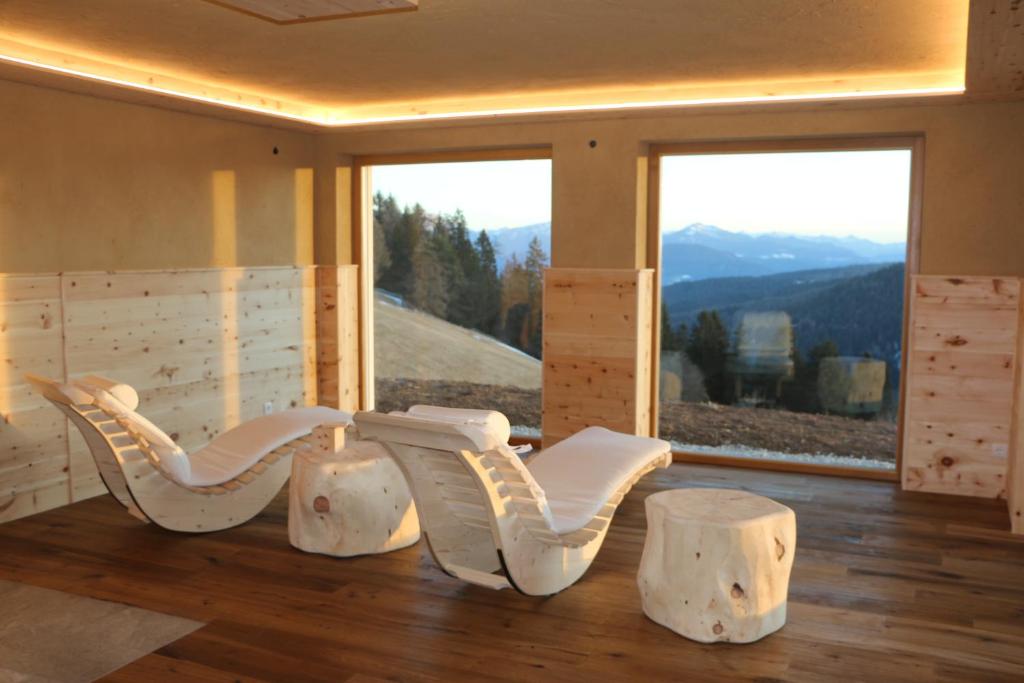 Zimmer mit zwei weißen Stühlen und einem großen Fenster in der Unterkunft Oberfahrerhof in Jenesien