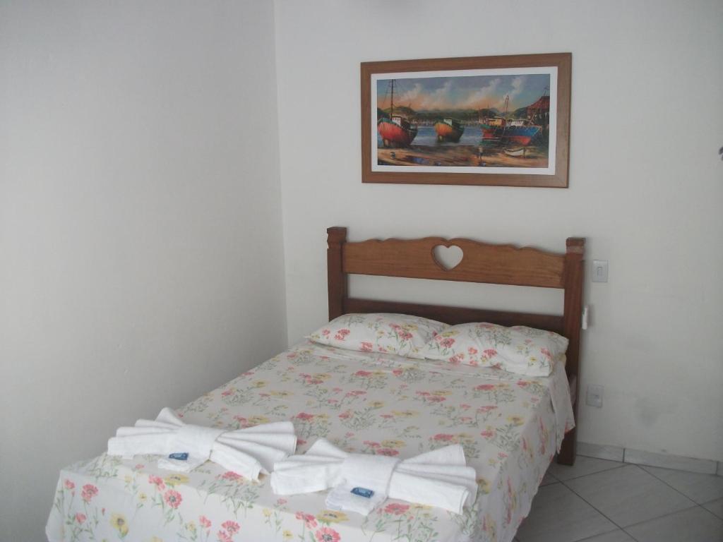 a bedroom with a bed and a picture on the wall at Casa do Gilberto in Ilhabela