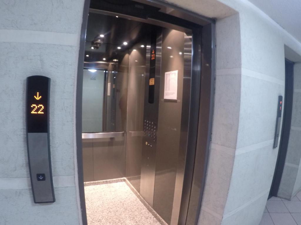 an elevator in a building with a glass door at America Departamentos in Santiago