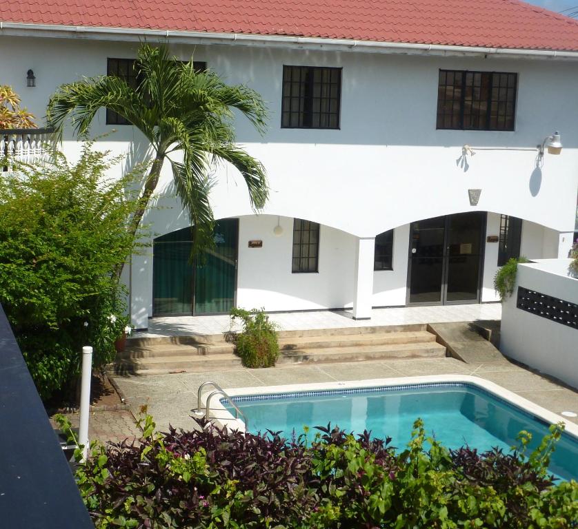 a house with a swimming pool and a palm tree at The Hummingbird in Crown Point