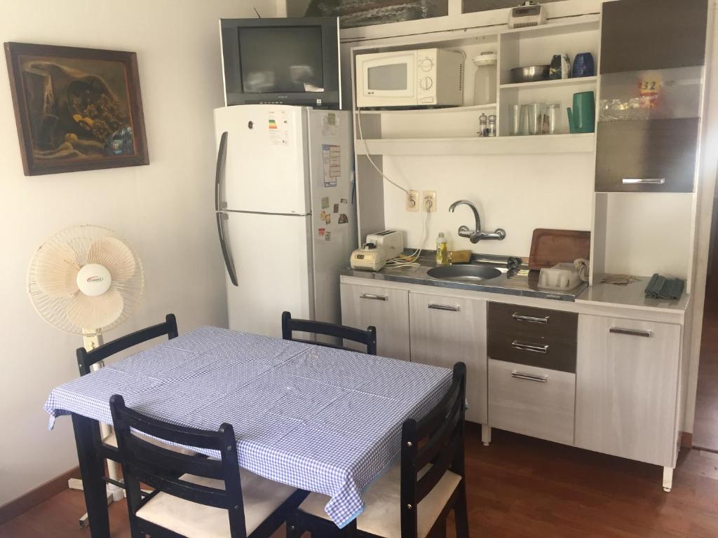 uma cozinha com uma mesa e um frigorífico branco em Apartamento aire acondicionado, wifi, Netflix,cerca de la Playa Mansa y Centro Maldonado em Maldonado