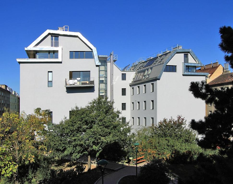 a large white building next to a taller white building at My Home in Vienna - Smart Apartments - Landstraße in Vienna