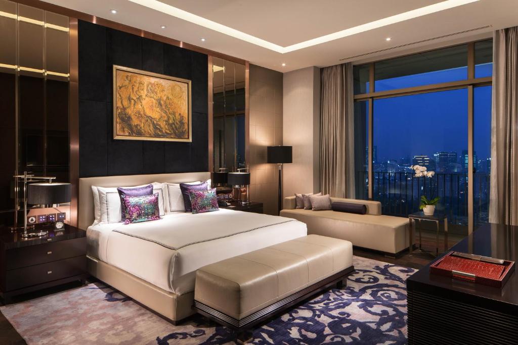 a bedroom with a large white bed and a large window at Fairmont Jakarta in Jakarta