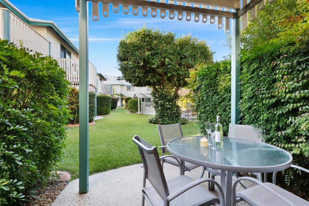 a glass table and chairs on a patio at Terrapin Apartments in Noosaville