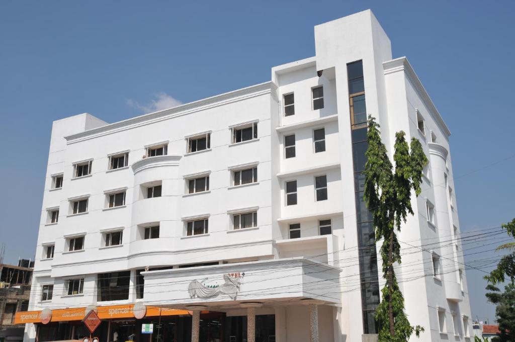 Hotel Vijayentra في بونديتْشيري: مبنى ابيض كبير مع شارع