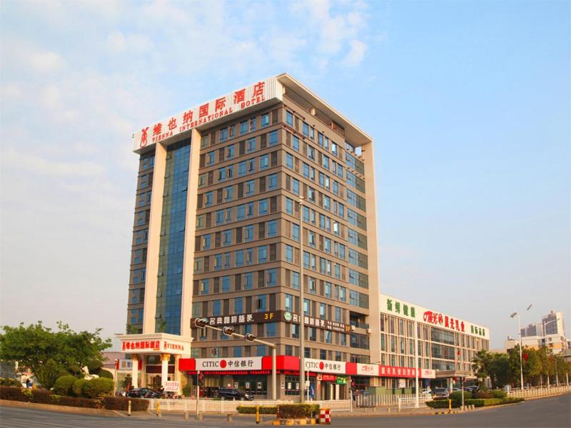 un grande edificio con un cartello sopra di Vienna International Hotel Shenzhen Guangming Avenue a Bao'an