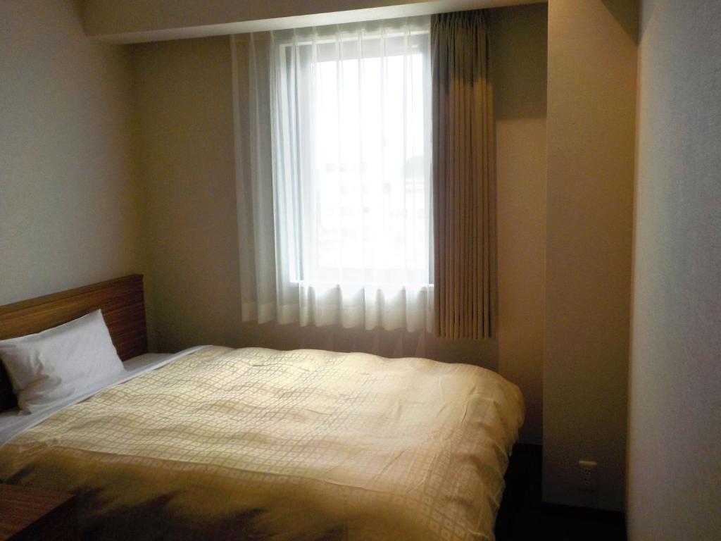 Postel nebo postele na pokoji v ubytování Hotel Crown Hills Katsuta Nigo Motomachiten