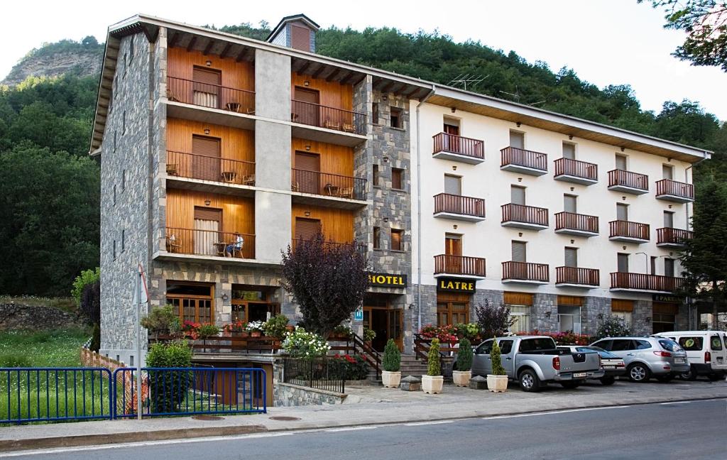 un gran edificio con coches estacionados frente a él en Hotel Latre, en Broto