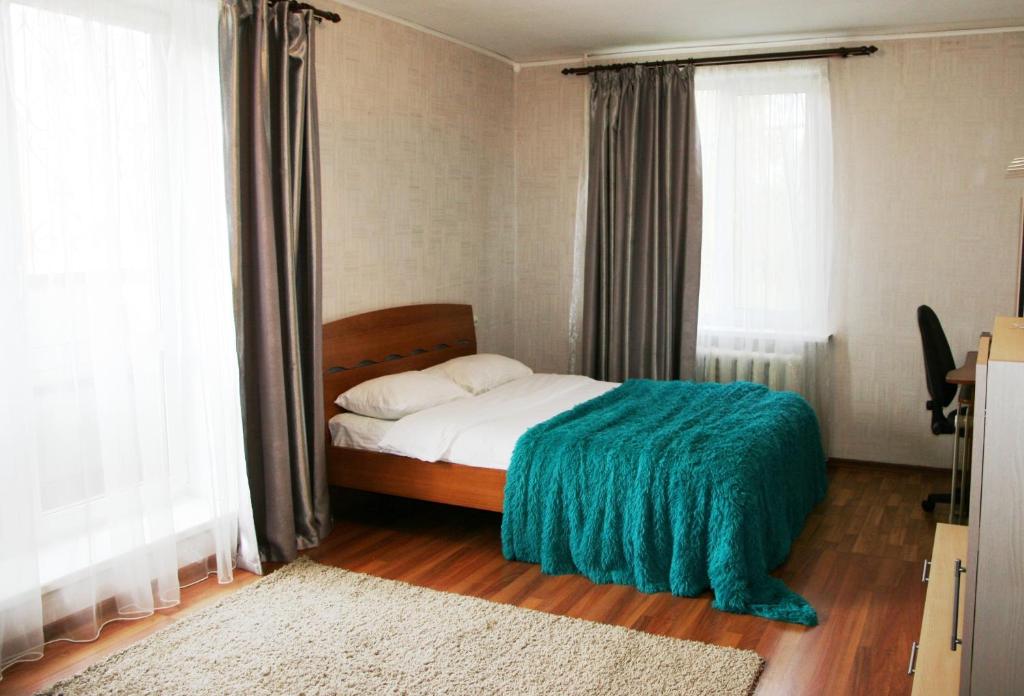ベレズニキにあるApartments on Parizhskoy Kommuny 50のベッドルーム1室(緑の毛布付きのベッド1台付)
