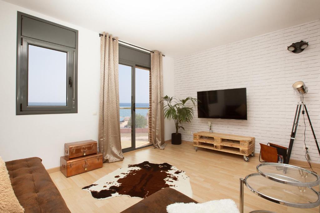 salon z kanapą i telewizorem z płaskim ekranem w obiekcie Apartment Beach Front Canet w mieście Canet de Mar