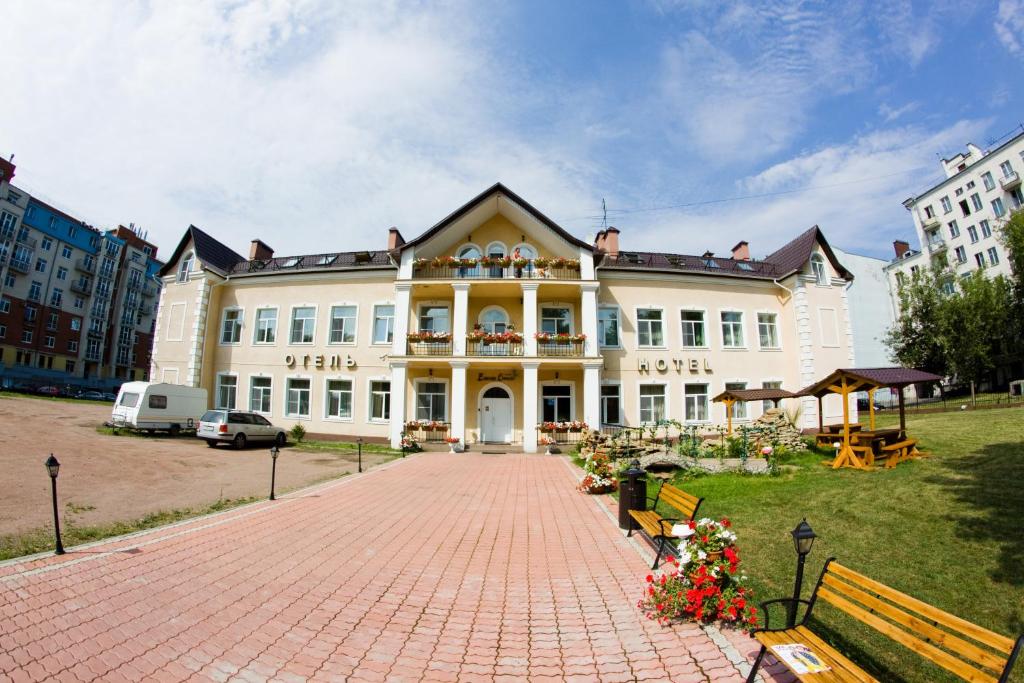 a large white building with a brick path in front of it at Elizar Hotel in Saint Petersburg
