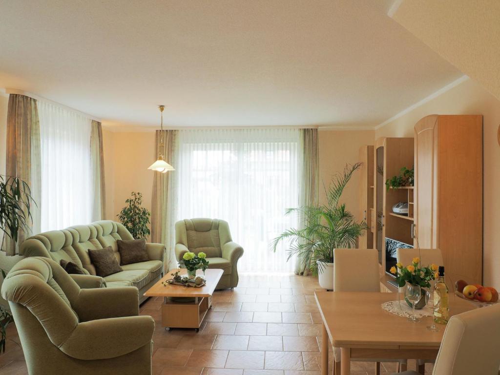 キュールングスボルンにあるModern Apartment in Kuhlungsborn with Gardenのリビングルーム(ソファ、椅子、テーブル付)