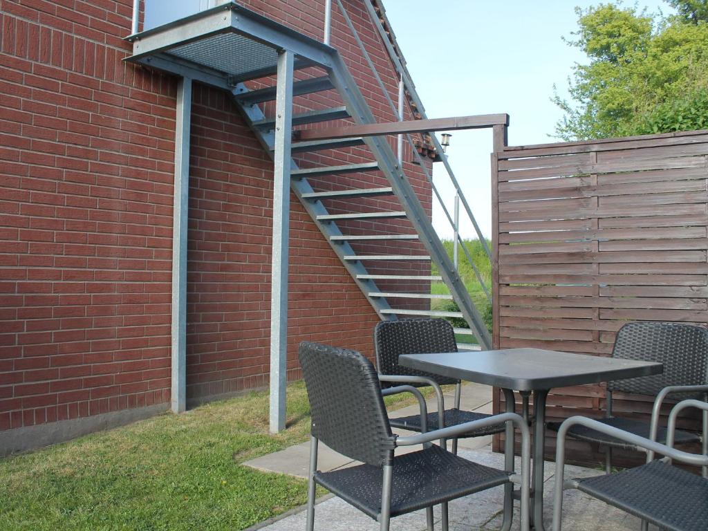 d'une terrasse avec une table et des chaises à côté d'un mur en briques. dans l'établissement Modern Apartment near Sea in Tranewitz, à Tarnewitz