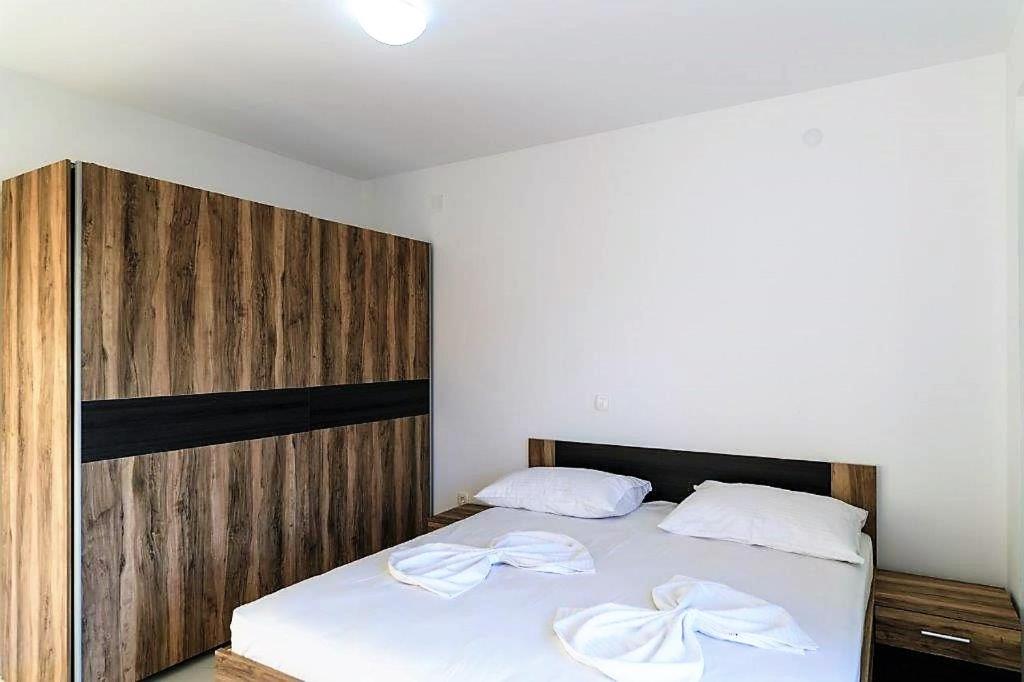 sypialnia z łóżkiem z drewnianym zagłówkiem w obiekcie VIP Deluxe Villa JASMINA w Novalji