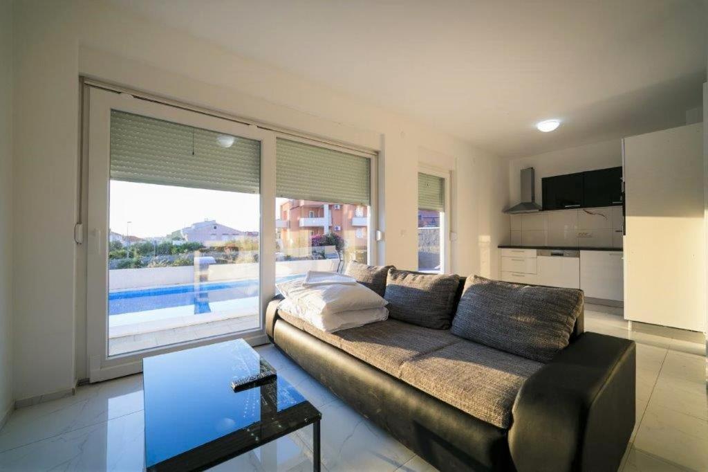 salon z kanapą i dużym oknem w obiekcie VIP Deluxe Villa JASMINA w Novalji