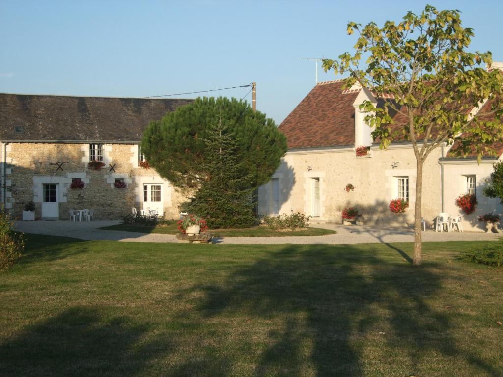 Sennevières的住宿－chambres des rosiers，一座白色的大建筑,院子中有一棵树