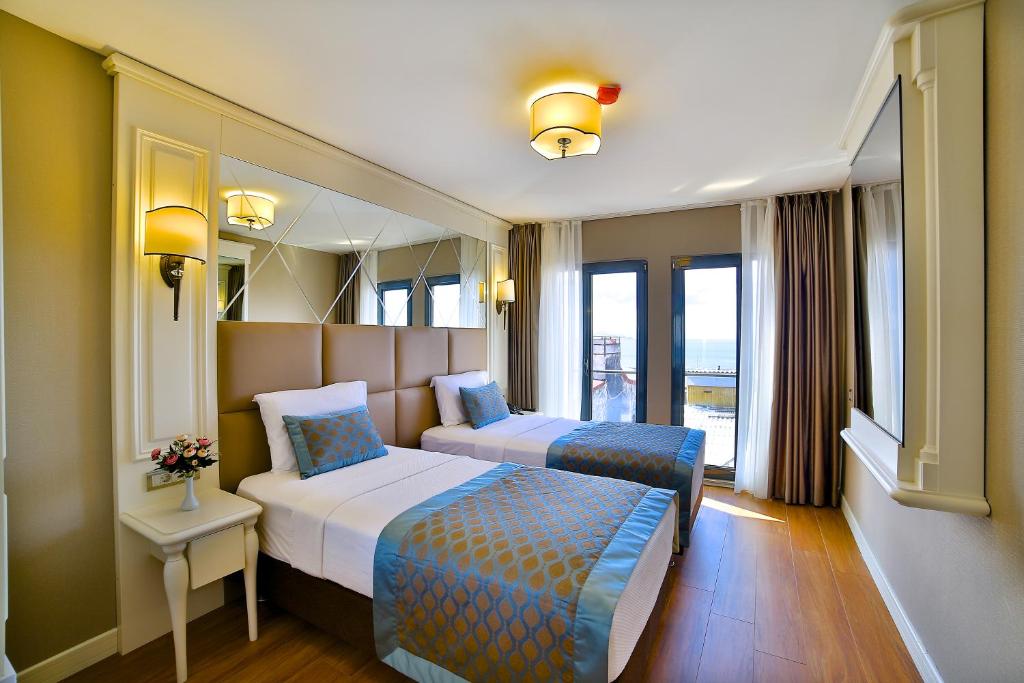 イスタンブールにあるBeethoven Hotel & Suiteのベッド2台と鏡が備わるホテルルームです。