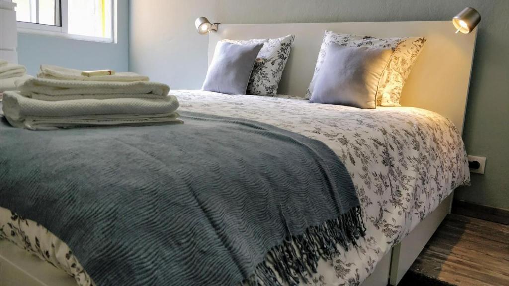a bedroom with a large bed with pillows at Lost in Terceira in Angra do Heroísmo