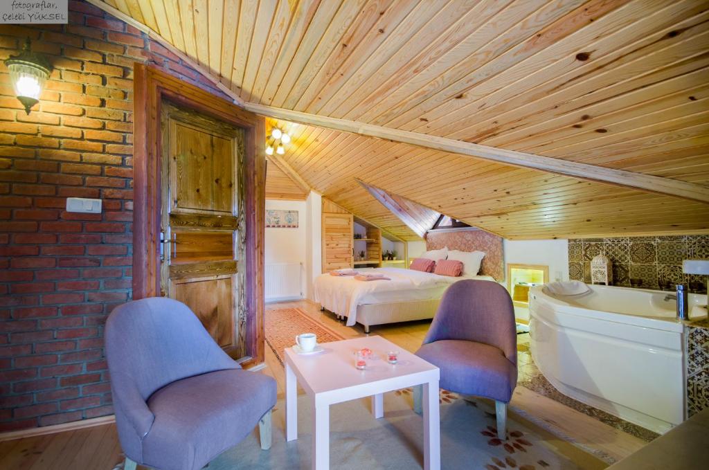 a bedroom with a bed and a bathtub and a room with a bed at Agva Piazza Hotel in Ağva