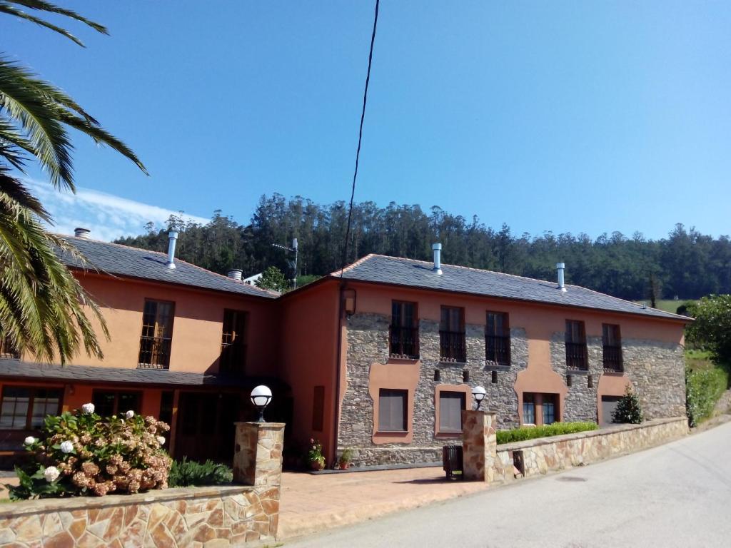 an old stone building with black windows and a palm tree at La Searila in Seares