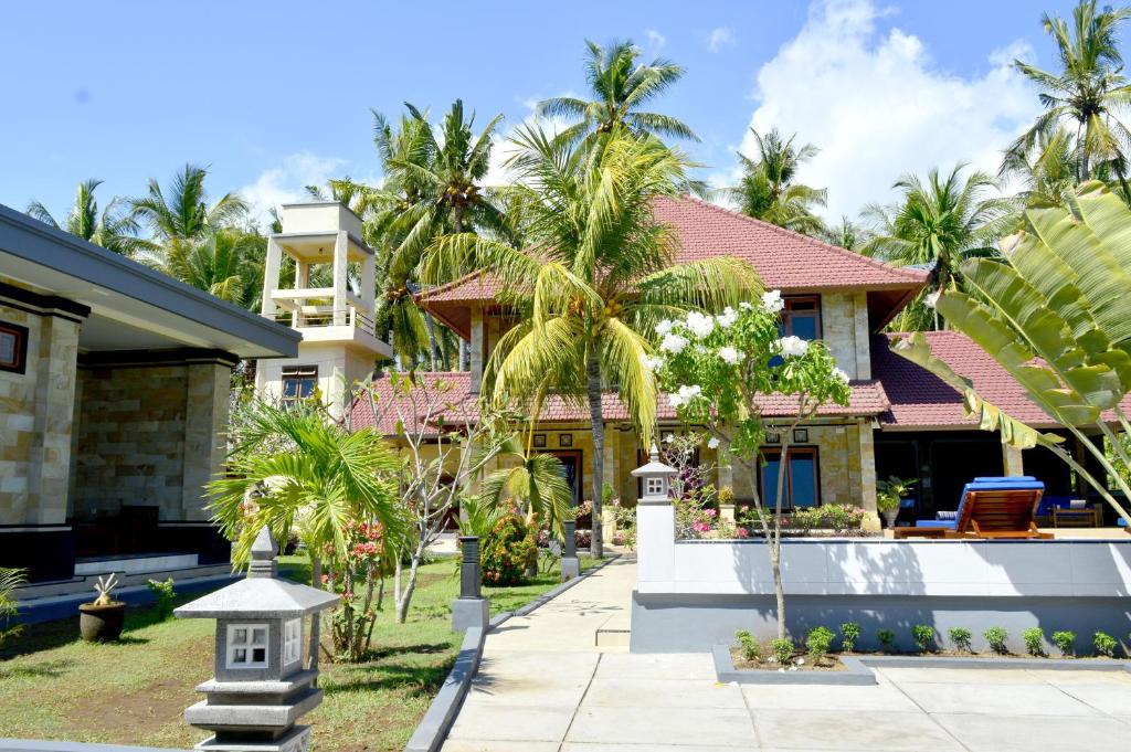 een huis met palmbomen ervoor bij Villa Romy and Bungalows in Lovina