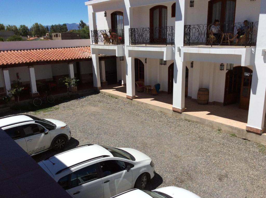 dos autos blancos estacionados frente a un edificio en La Ramada en Cafayate