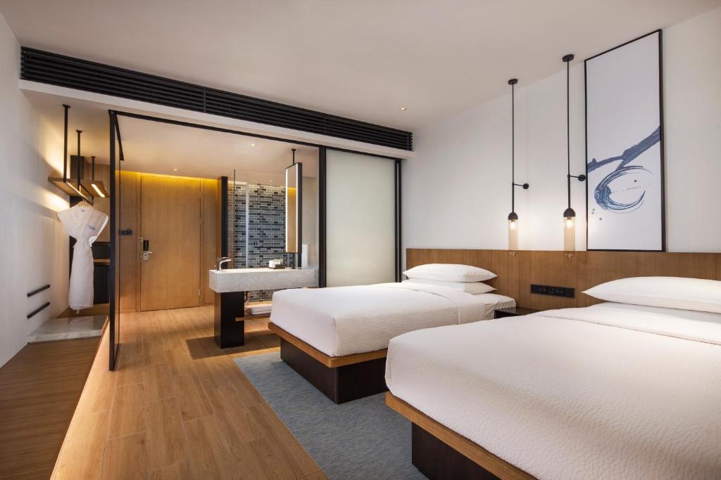 Fairfield by Marriott Dongguan Changping في دونغقوان: غرفة فندقية بسريرين ومغسلة