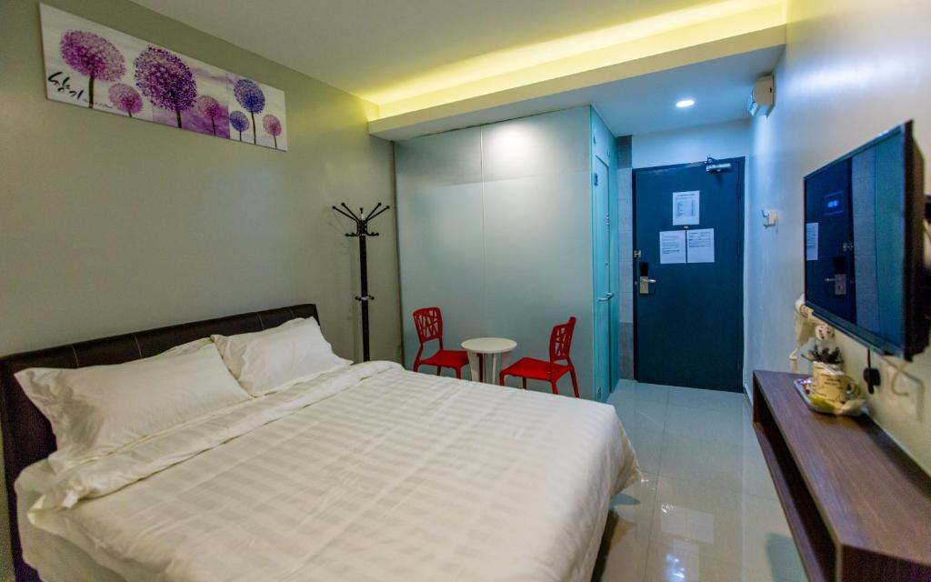 a bedroom with a bed and a desk at U Plus Budget Hotel in Bukit Mertajam