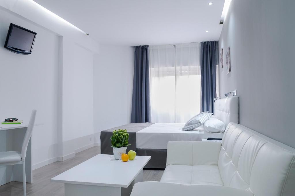 a white room with a bed and a couch at Boutique Urban Madrid Serrano in Madrid