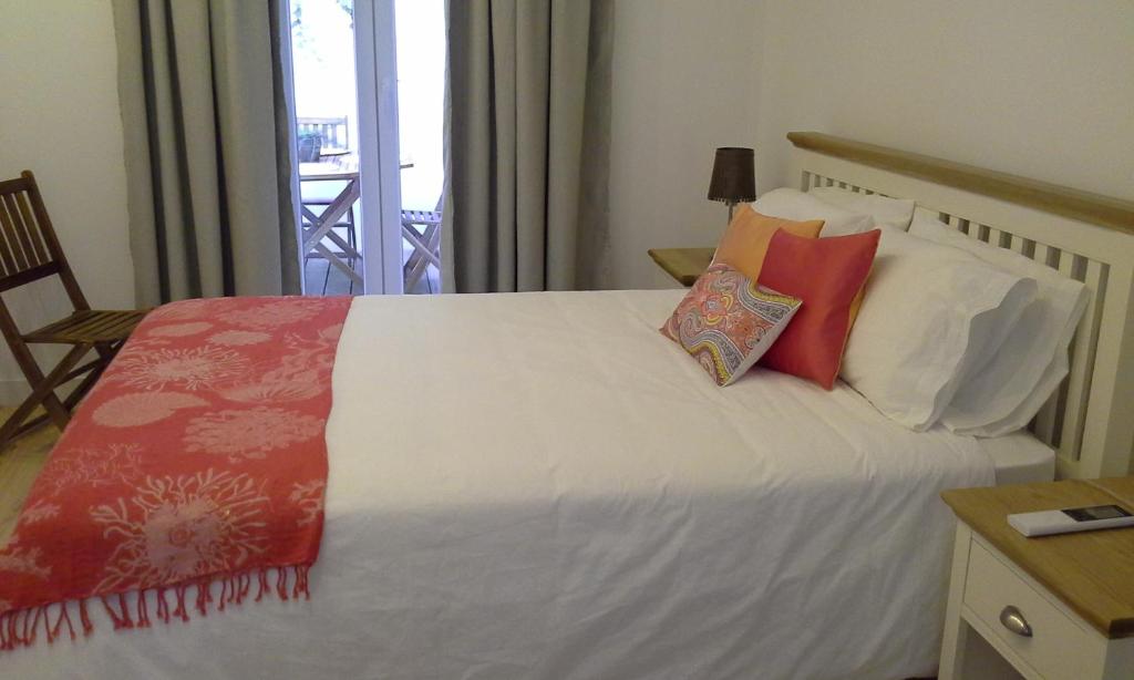 1 dormitorio con 1 cama con almohadas rojas y blancas en ChezVous Apartments, en Lisboa