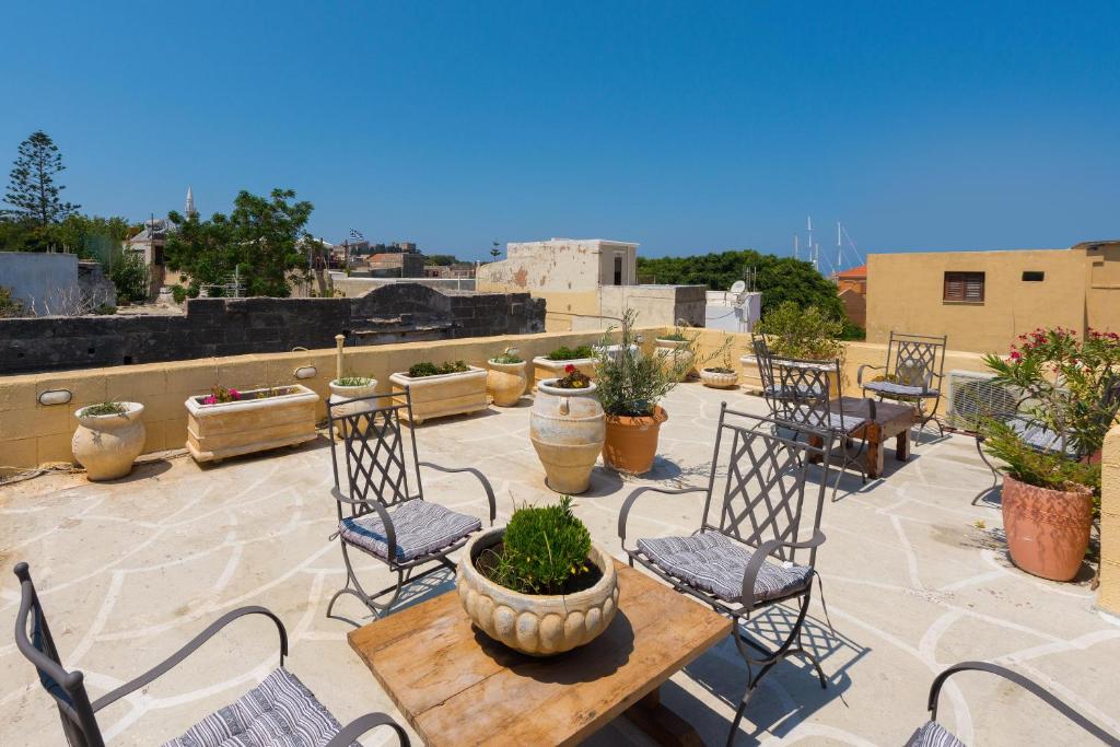 un patio con sillas y una mesa con plantas en Spot Hotel, en Rodas