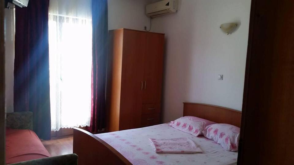 1 dormitorio con 1 cama, armario y ventana en Rooms Ajllin, en Ulcinj