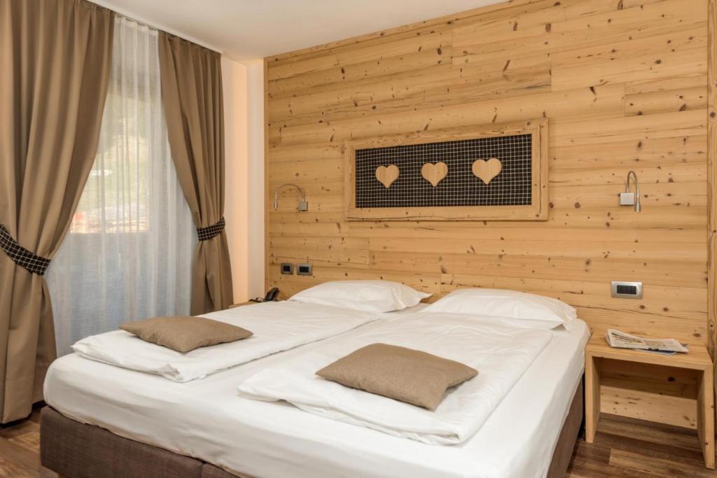 A bed or beds in a room at Hotel Garni Lastei