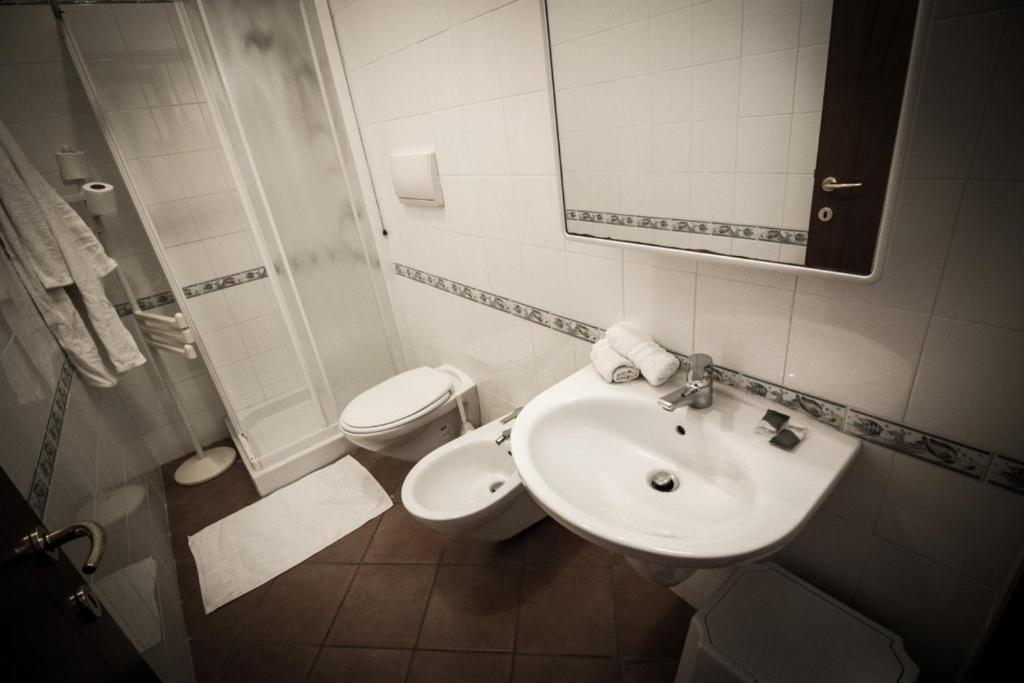 bagno con lavandino, servizi igienici e specchio di Jonio Vacanze Residence a Castellaneta Marina