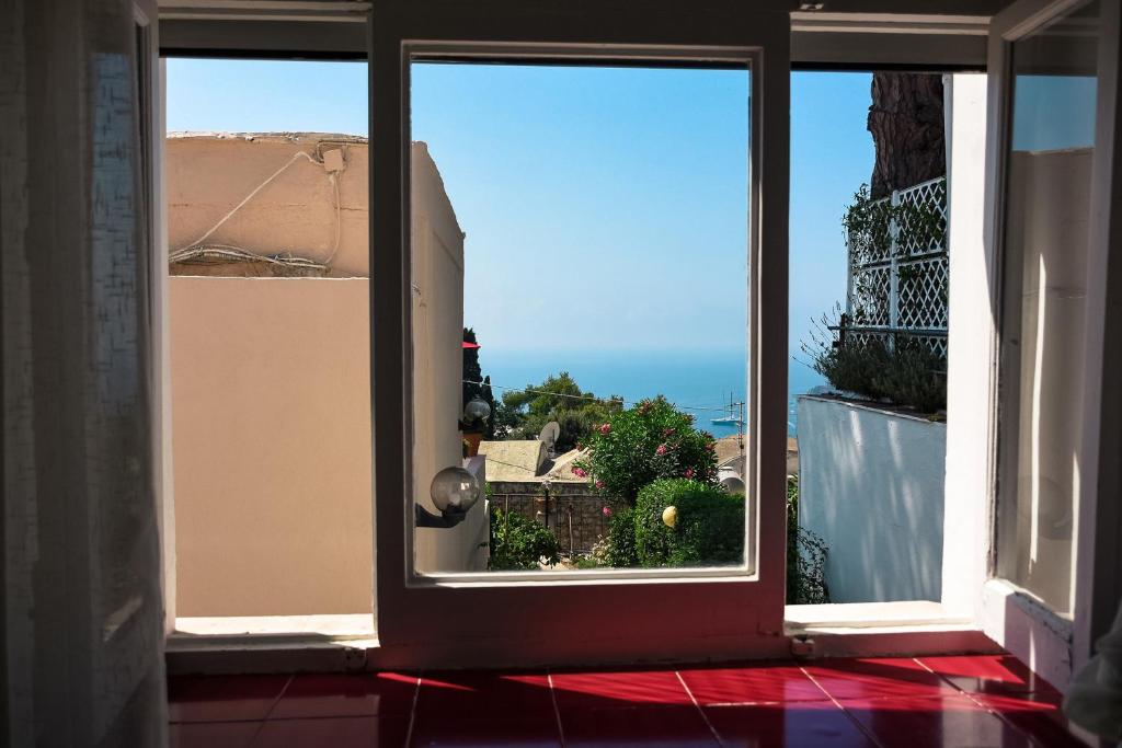 an open door to a balcony with a view of the ocean at La Reginella Capri in Capri