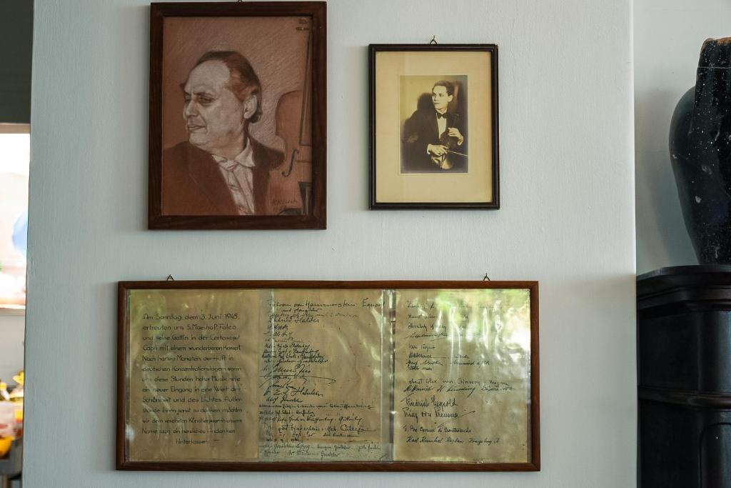 two framed pictures of a man on a wall with a document at La Reginella Capri in Capri