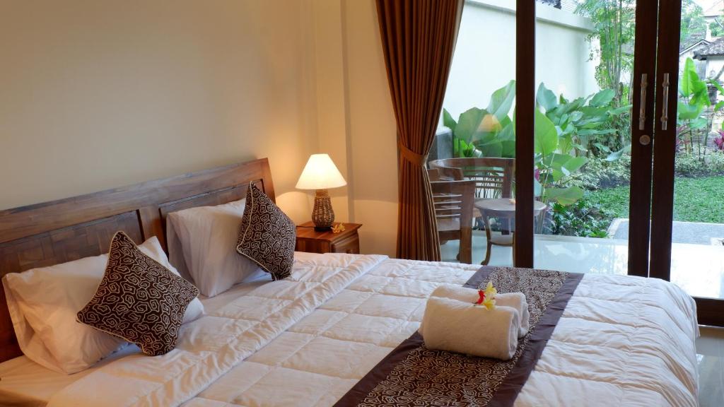 a bedroom with a bed with a candle on it at Boge House in Ubud
