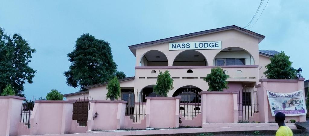 ein rosafarbenes Gebäude mit einem Miss-Lodge-Schild darauf in der Unterkunft Nass Lodge in Sunyani