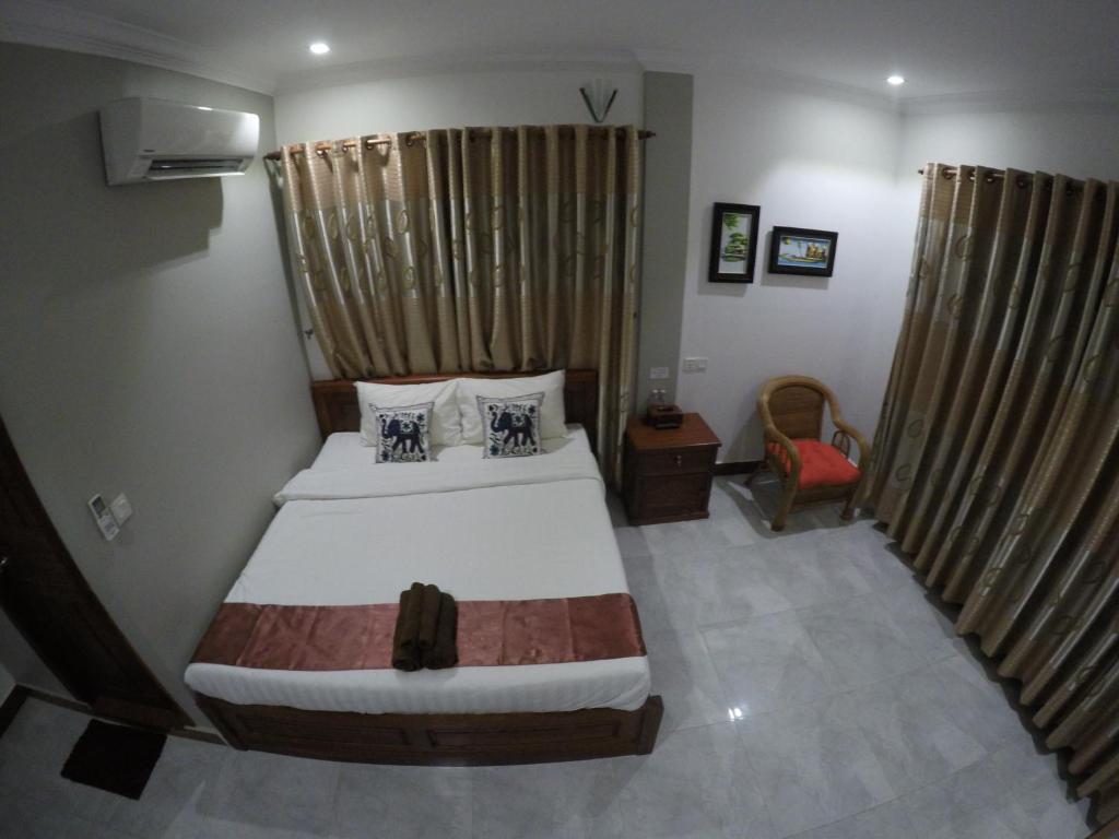 貢布的住宿－幸福家庭旅館，一间小卧室,配有一张床和一把椅子