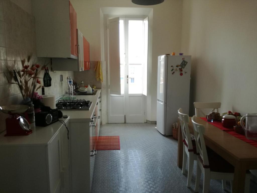 una cucina con frigorifero e tavolo con sedie di Treehouse a Pisa
