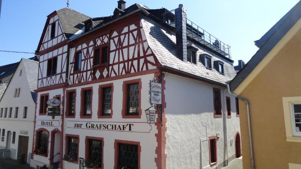 un edificio blanco alto con un letrero. en Hotel zur Grafschaft, en Brauneberg