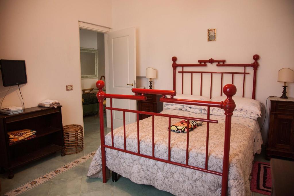 a bedroom with a red bed and a television at Mamita villa in Fiumicino