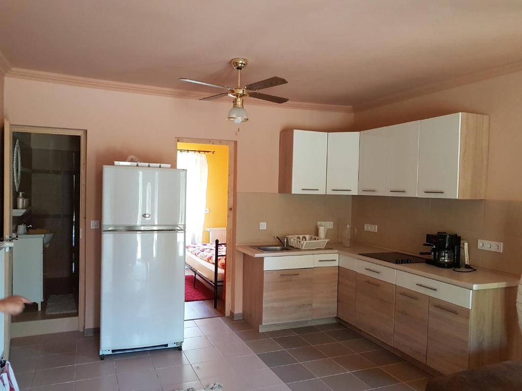 a kitchen with white cabinets and a white refrigerator at Etyek Rustic Home in Etyek