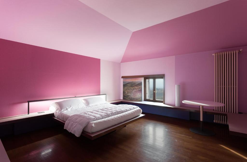 サンタンブロージョ・ディ・ヴァルポリチェッラにあるLa Grande Casa Valpolicellaの紫色のベッドルーム(ベッド1台、テーブル付)