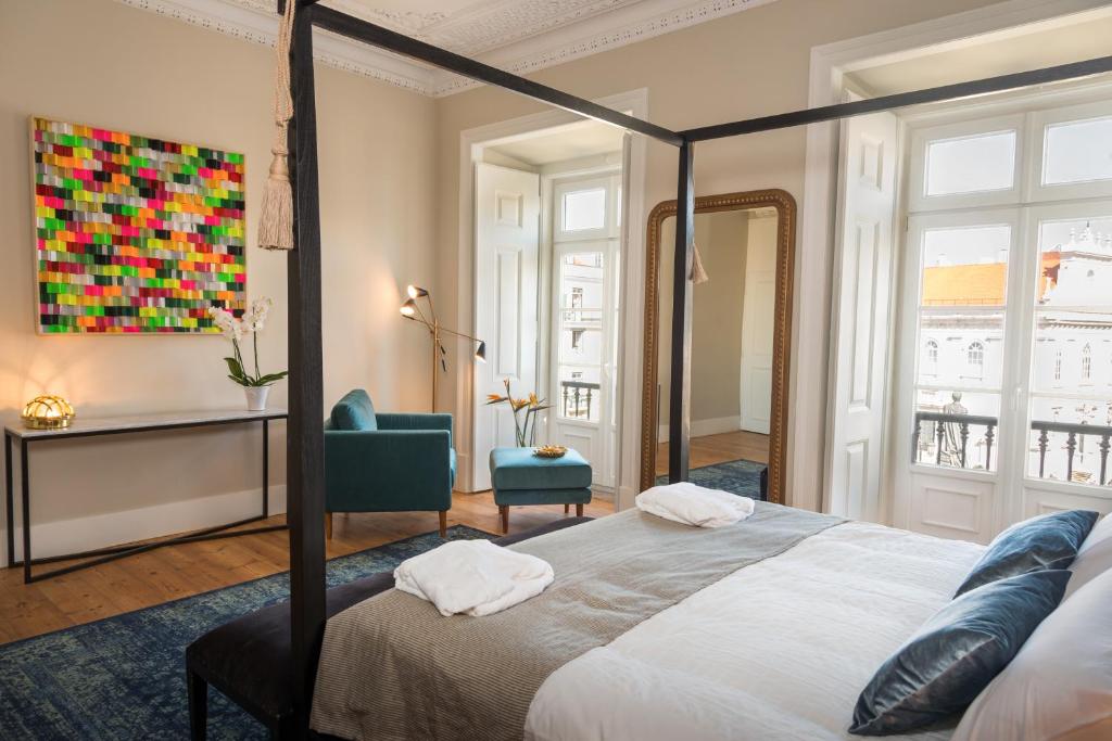 a bedroom with a bed and a chair and a painting at Le Consulat in Lisbon